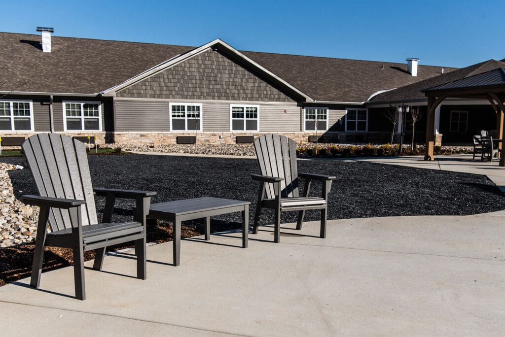 Outdoor seating area with Adirondack chairs for relaxing at Charter Senior Living of White House in Tennessee.